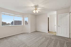 Unfurnished room featuring light colored carpet and ceiling fan