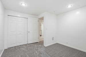 Unfurnished bedroom with a closet, carpet flooring, and recessed lighting
