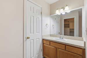 Bathroom with vanity and a walk in closet