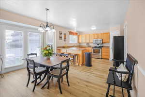Dining room featuring light wood-type flooring and a chandelier