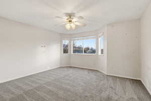Unfurnished room with carpet and a ceiling fan