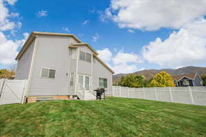 Rear view of property featuring a gate, a fenced backyard, a mountain view, and entry steps