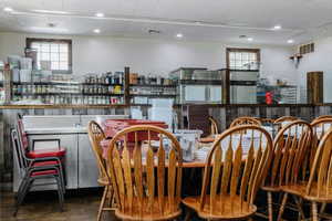 Dining room featuring wood finished floors, bar with sink, and recessed lighting