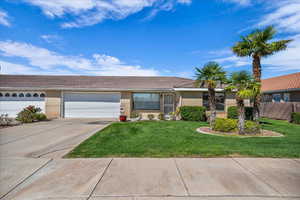 Ranch-style house featuring brick siding, a front yard, concrete driveway, and a garage