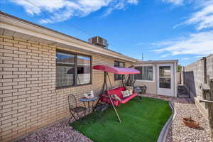Rear view of house featuring a fenced backyard and brick siding