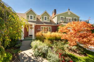 Cape cod-style house featuring roof with shingles, board and batten siding, and brick siding