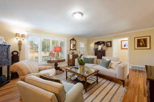 Living area featuring crown molding and wood finished floors