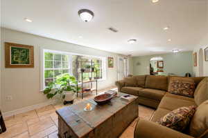 Living area featuring recessed lighting, stone tile floors, and arched walkways
