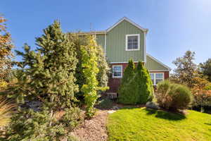 View of home's exterior featuring a lawn, brick siding, and board and batten siding