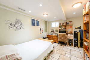 Bedroom featuring beamed ceiling, recessed lighting, stone tile floors, and a desk