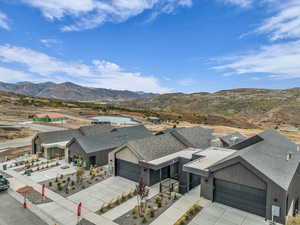 View of front facade featuring an attached garage, a mountain view, driveway, and a residential view