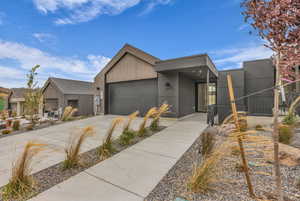 Contemporary house featuring concrete driveway and a garage