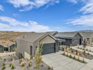 Contemporary house with a garage, driveway, a mountain view, and roof with shingles