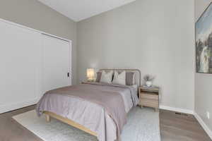 Bedroom featuring wood finished floors and a closet