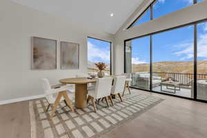 Dining space with high vaulted ceiling, light wood finished floors, recessed lighting, and a mountain view
