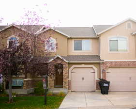Traditional home featuring concrete driveway, stucco siding, and a garage