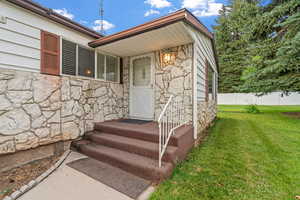 Entrance to property featuring stone siding