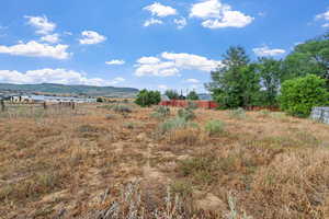 Back half acre view of yard featuring a mountain view and a view of countryside