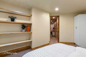 Bedroom featuring light tile patterned flooring, recessed lighting, and ensuite bath