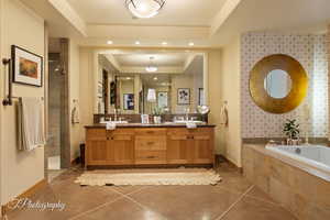 Full bathroom featuring a garden tub, a tile shower, double vanity, a tray ceiling, and recessed lighting