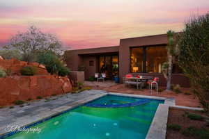 View of swimming pool with a patio area, a pool with connected hot tub, and an outdoor living space