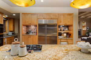 Kitchen featuring black appliances, light stone counters, decorative backsplash, light brown cabinetry, and recessed lighting