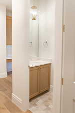 Half bathroom featuring vanity and tasteful backsplash