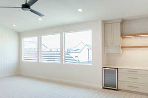 Bar featuring beverage cooler, backsplash, open shelves, recessed lighting, and light stone counters