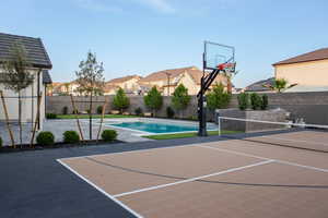 View of basketball court featuring a fenced backyard, a residential view, a patio, a tennis court, and basketball hoop