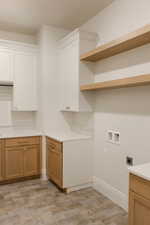 Washroom with cabinet space, hookup for an electric dryer, and hookup for a washing machine