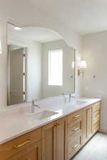 Bathroom with double vanity and light tile patterned floors