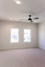 Empty room with light colored carpet, plenty of natural light, and recessed lighting