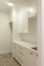 Kitchen featuring white cabinetry and baseboards