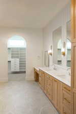 Full bath featuring double vanity and baseboards