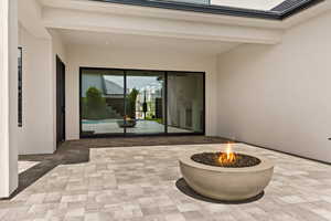 View of exterior entry with a patio area and stucco siding