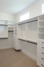 Spacious closet featuring light colored carpet