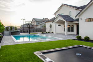 View of pool featuring a patio, a pool with connected hot tub, and a fenced backyard