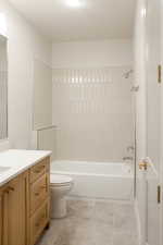 Bathroom with shower / washtub combination, vanity, and light tile patterned floors