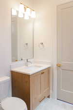 Half bath with vanity and tile patterned floors