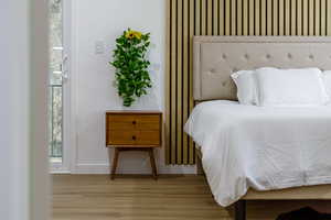 Bedroom featuring wood finished floors and multiple windows