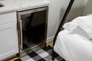 Bedroom view of wine cooler and wood finished floors