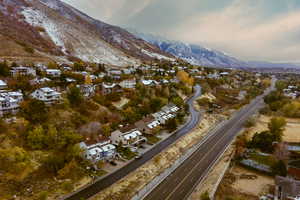 Aerial view of property and surrounding area with a mountainous background and nearby suburban area