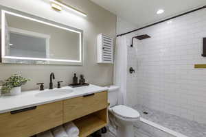 Bathroom with vanity, a shower stall, and recessed lighting