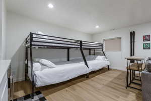 Bedroom featuring light wood-style flooring, recessed lighting, a textured ceiling, and beverage cooler