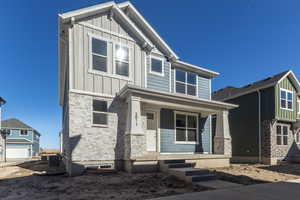 Craftsman inspired home with board and batten siding, stone siding, and covered porch