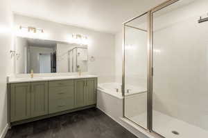 Full bathroom featuring a bath, a marble finish shower, double vanity, and dark wood-style floors