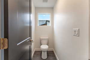 Bathroom featuring toilet and baseboards