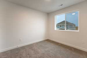 Carpeted empty room featuring baseboards