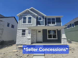 View of front of property featuring stone siding, covered porch, and board and batten siding