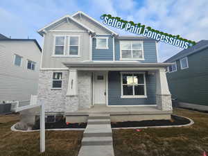 View of front of home featuring stone siding, a porch, and board and batten siding